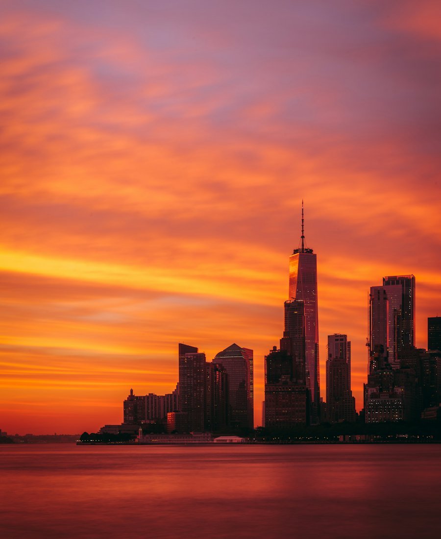 The Manhattan skyline silhouetted against a fiery sunset