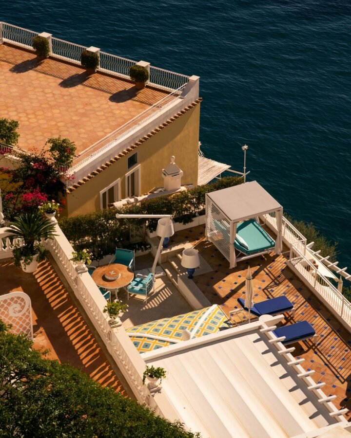 A clifftop terrace with lounge chairs overlooking the sea on the Amalfi Coast